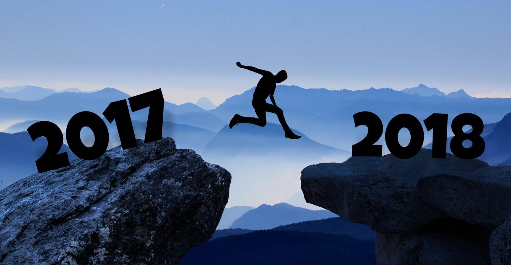 Silhouette of person jumping between rocks labeled 2017 and 2018