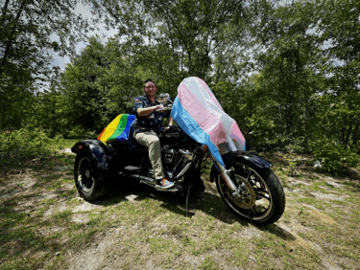 Person riding motorcycle with colorful flowing fabric