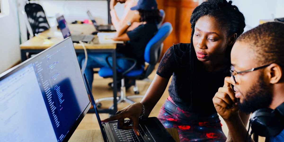 People working at desk with laptop computer in office environment